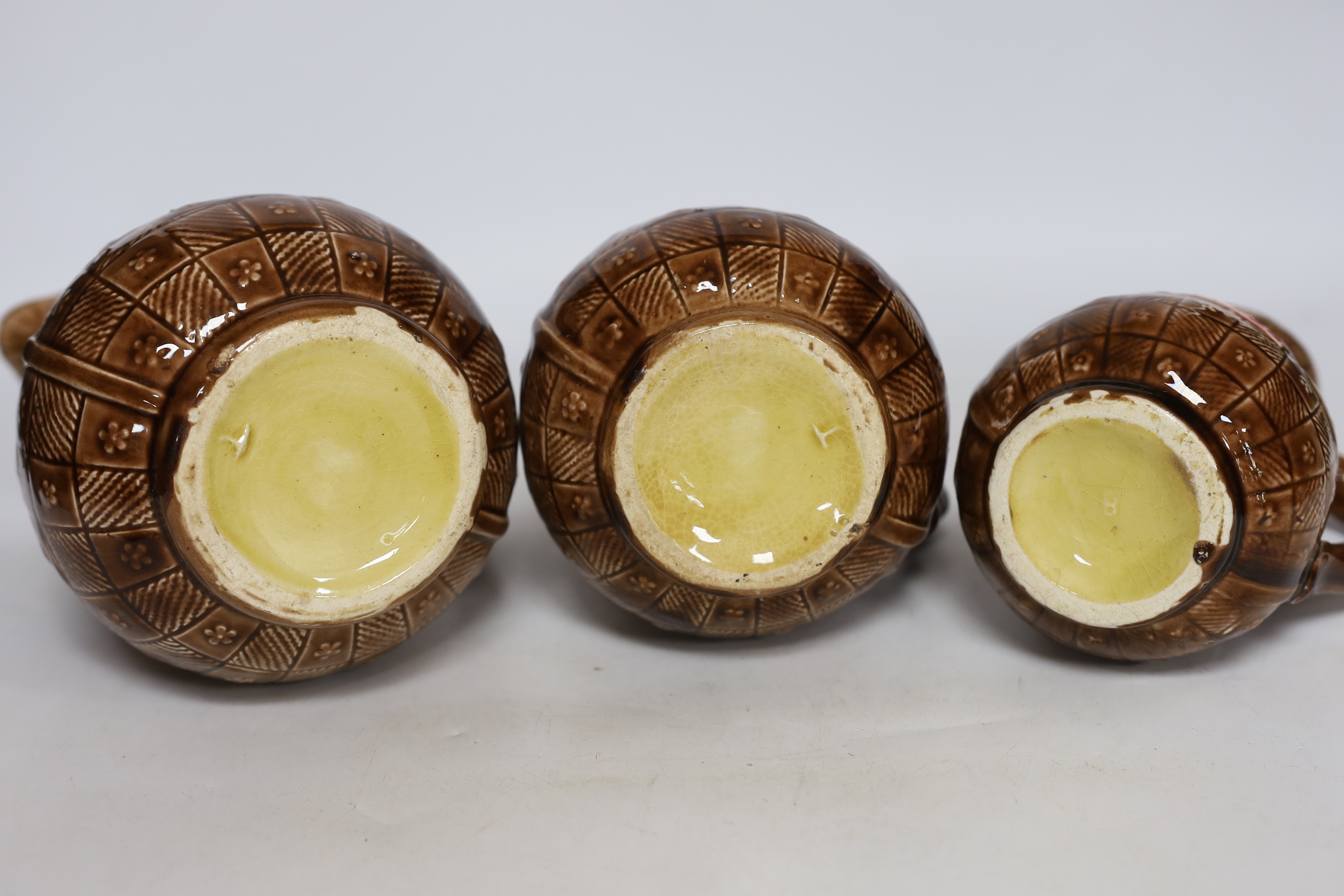 A set of three Aesthetic period graduated majolica jugs, tallest 19.5cm